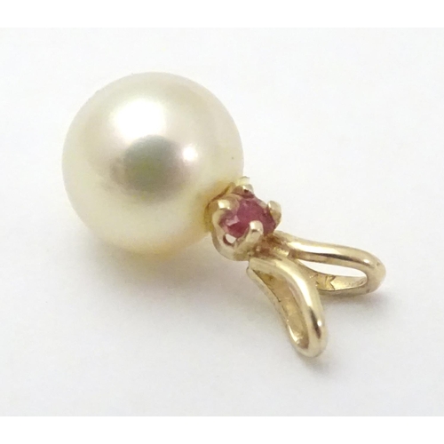 530 - A 9ct gold pendant set with pearl and red spinel. Approx 1 /4