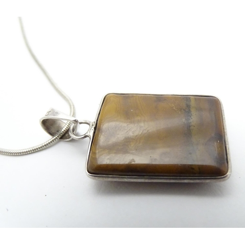 537 - A silver pendant and chain, the pendant set with polished agate hardstone. Approx 1 1/2