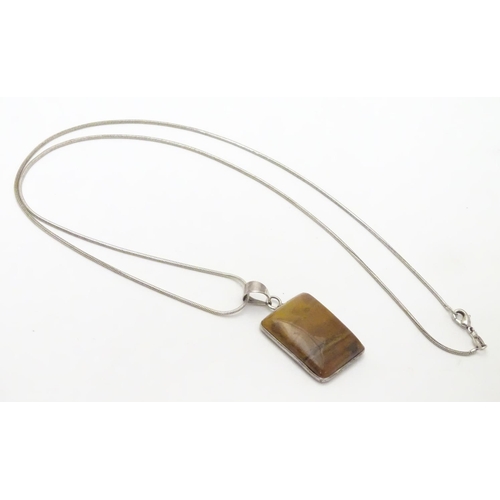 537 - A silver pendant and chain, the pendant set with polished agate hardstone. Approx 1 1/2