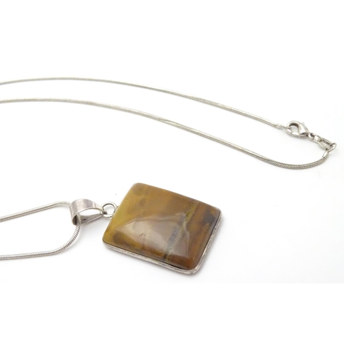 537 - A silver pendant and chain, the pendant set with polished agate hardstone. Approx 1 1/2