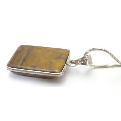 537 - A silver pendant and chain, the pendant set with polished agate hardstone. Approx 1 1/2