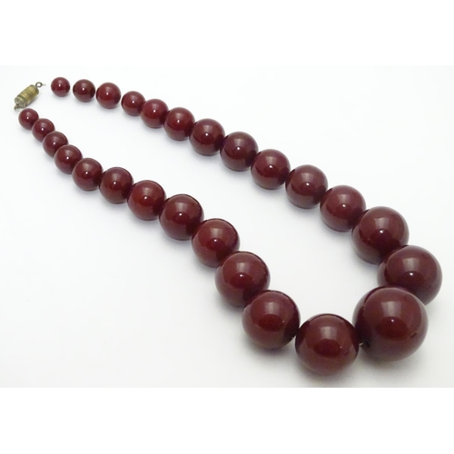 550 - A vintage necklace of graduated  cherry amber Bakelite beads. Approx 15