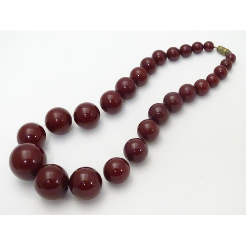 550 - A vintage necklace of graduated  cherry amber Bakelite beads. Approx 15