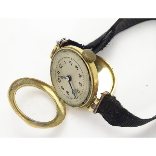 558 - An early 20thC Ladies' wrist watch , with fabric strap and 18ct gold case