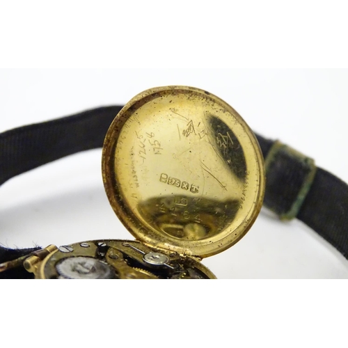 558 - An early 20thC Ladies' wrist watch , with fabric strap and 18ct gold case