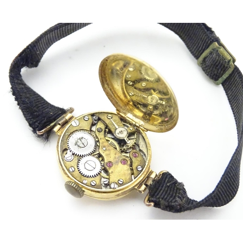 558 - An early 20thC Ladies' wrist watch , with fabric strap and 18ct gold case