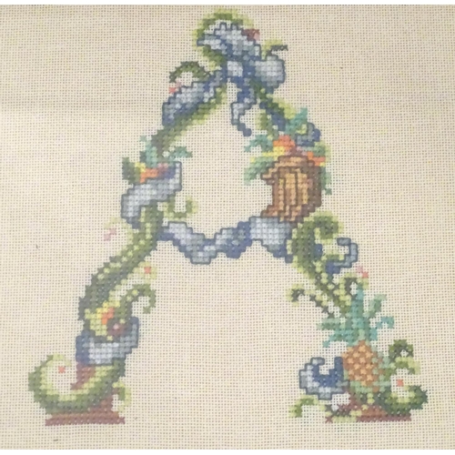 676 - A 20thC cross stitch embroidery / needlework depicting the alphabet letter A formed from stylised fl... 