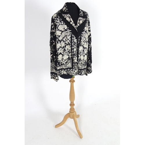 722 - An oriental silk black vintage jacket, embroidered with cream flowers, birds and butterflies. Bust s... 