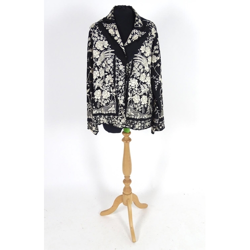 722 - An oriental silk black vintage jacket, embroidered with cream flowers, birds and butterflies. Bust s... 