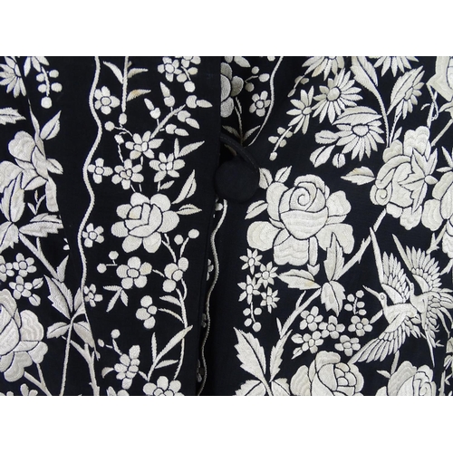 722 - An oriental silk black vintage jacket, embroidered with cream flowers, birds and butterflies. Bust s... 