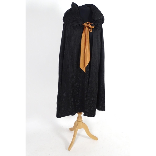 730 - A bespoke vintage ladies black evening cape, with padded collar, tie to neck. Bronze/orange lining. ... 