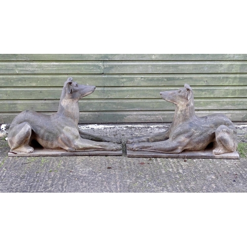 782 - Garden & Architectural, Salvage: a pair of stone garden ornaments formed as couchant hounds / dogs u... 