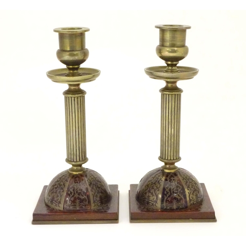 805 - A pair of 19thC Regency brass and tortoiseshell Boulle candlesticks with domed square bases and reed... 