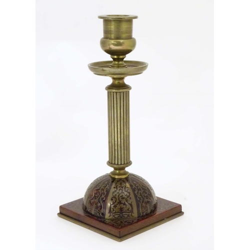 805 - A pair of 19thC Regency brass and tortoiseshell Boulle candlesticks with domed square bases and reed... 