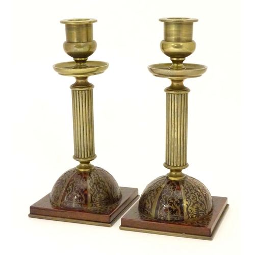 805 - A pair of 19thC Regency brass and tortoiseshell Boulle candlesticks with domed square bases and reed... 