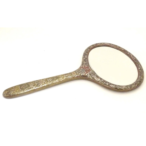 826 - A late 19th / early 20thC hand mirror with Damascene style decorative surround and oval bevelled edg... 