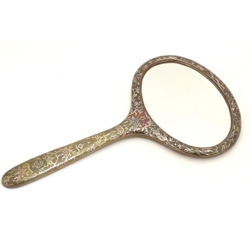 826 - A late 19th / early 20thC hand mirror with Damascene style decorative surround and oval bevelled edg... 