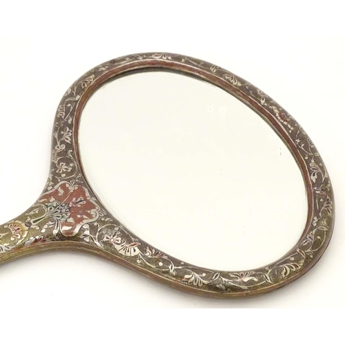 826 - A late 19th / early 20thC hand mirror with Damascene style decorative surround and oval bevelled edg... 