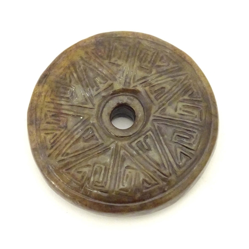 844 - A Chinese carved hardstone roundel with incised geometric detail. Approx. 2