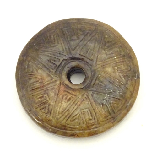 844 - A Chinese carved hardstone roundel with incised geometric detail. Approx. 2