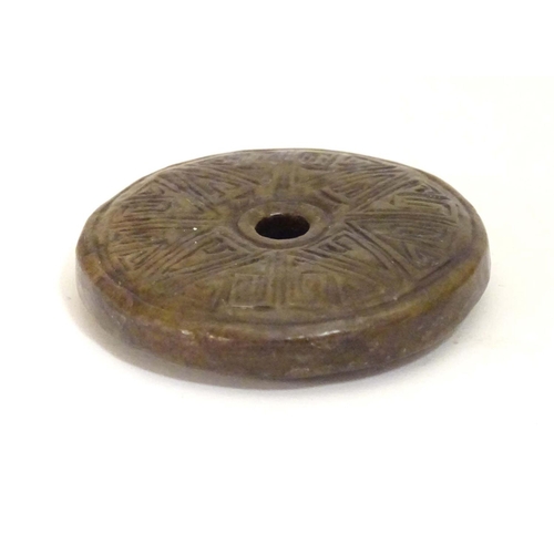 844 - A Chinese carved hardstone roundel with incised geometric detail. Approx. 2