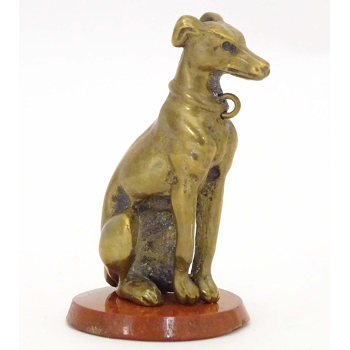 963 - A late 19th / early 20thC brass model of a seated dog on a circular hardstone base. Approx. 2 1/2