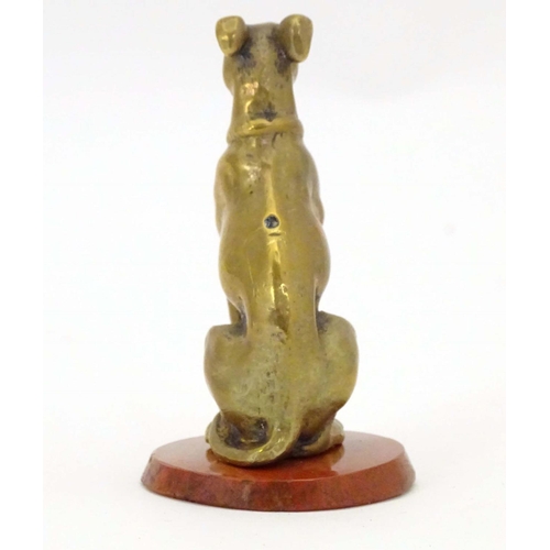 963 - A late 19th / early 20thC brass model of a seated dog on a circular hardstone base. Approx. 2 1/2