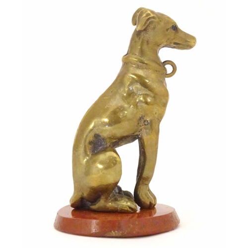 963 - A late 19th / early 20thC brass model of a seated dog on a circular hardstone base. Approx. 2 1/2