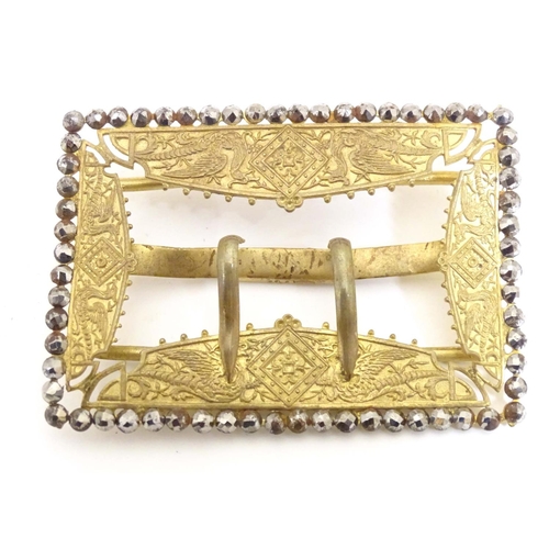 972 - A gilt metal buckle with stylised dragon detail and cut steel border. Together with a silver plate b... 