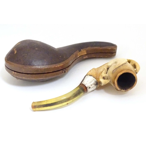 980 - An early 20thC cased carved meerschaum pipe, the bowl formed as an eagle talon, joined to the amber ... 