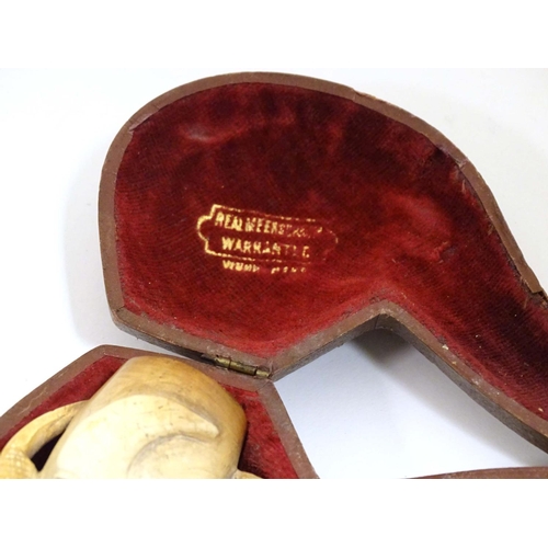 980 - An early 20thC cased carved meerschaum pipe, the bowl formed as an eagle talon, joined to the amber ... 