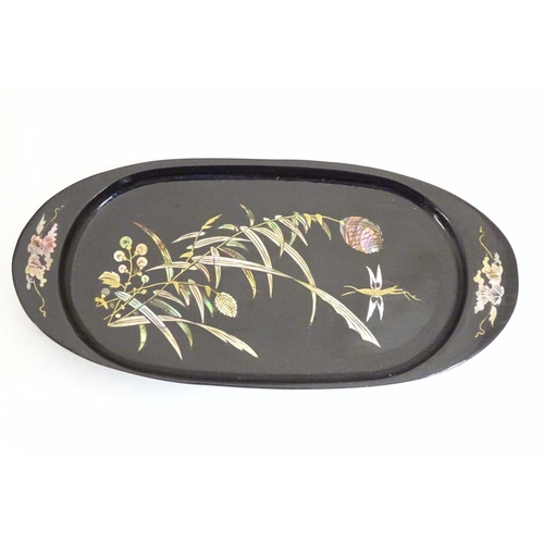 982 - An oval lacquered pin dish with inlaid abalone decoration depicting a stylised dragonfly with flower... 