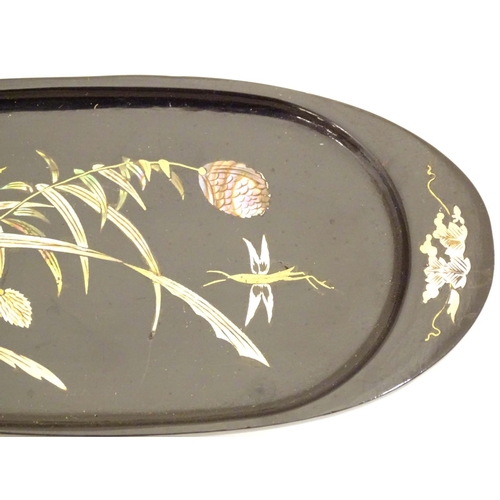 982 - An oval lacquered pin dish with inlaid abalone decoration depicting a stylised dragonfly with flower... 