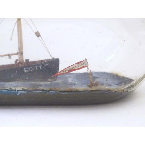 999 - A 20thC ship in a bottle / diorama depicting Kindred Star LT177, a steam trawler boat at sea. Approx... 