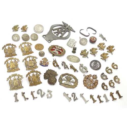 569 - Militaria: a collection of 20thC military badges, including an early 20thC white metal dog tag (insc... 