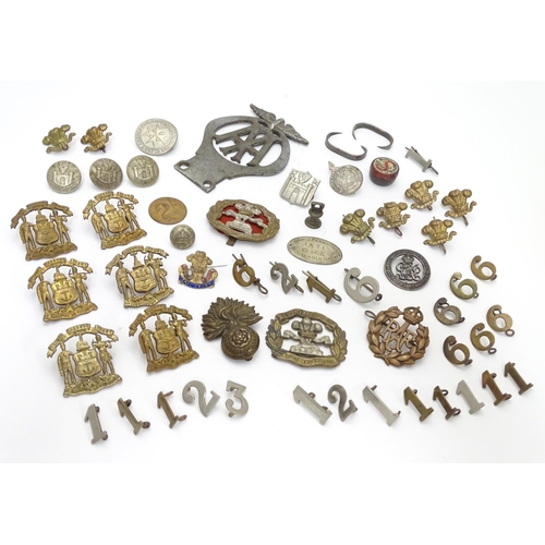 569 - Militaria: a collection of 20thC military badges, including an early 20thC white metal dog tag (insc... 