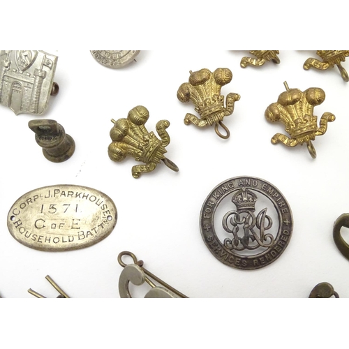 569 - Militaria: a collection of 20thC military badges, including an early 20thC white metal dog tag (insc... 