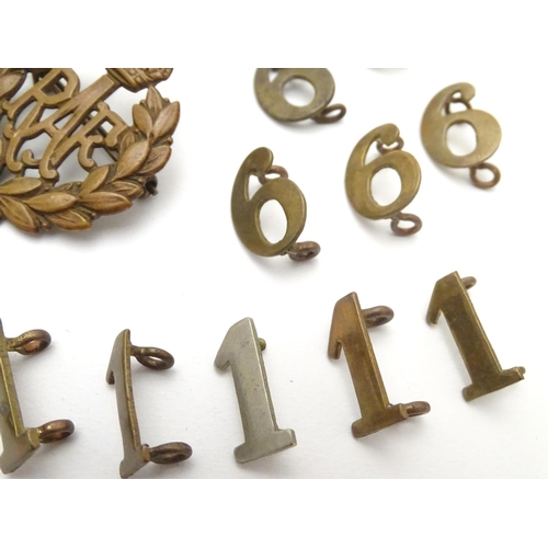 569 - Militaria: a collection of 20thC military badges, including an early 20thC white metal dog tag (insc... 