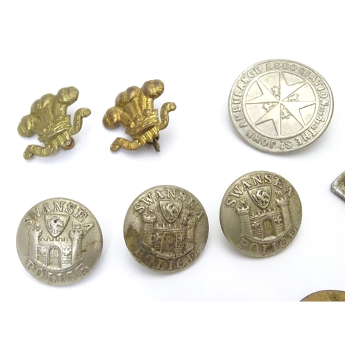 569 - Militaria: a collection of 20thC military badges, including an early 20thC white metal dog tag (insc... 