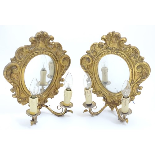 1204 - A pair of  late 20thC twin branch girandole wall lights with carved and moulded frame to mirror back... 