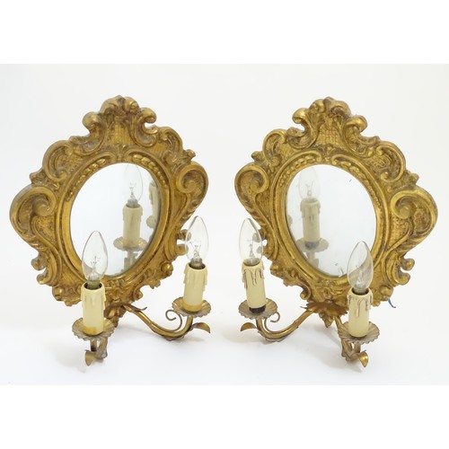 1204 - A pair of  late 20thC twin branch girandole wall lights with carved and moulded frame to mirror back... 