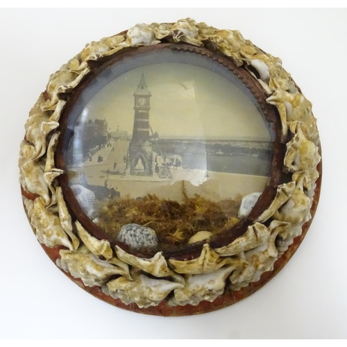 1000 - Three 20thC souvenir dioramas with shell art borders and printed coastal scenes, one depicting the t... 