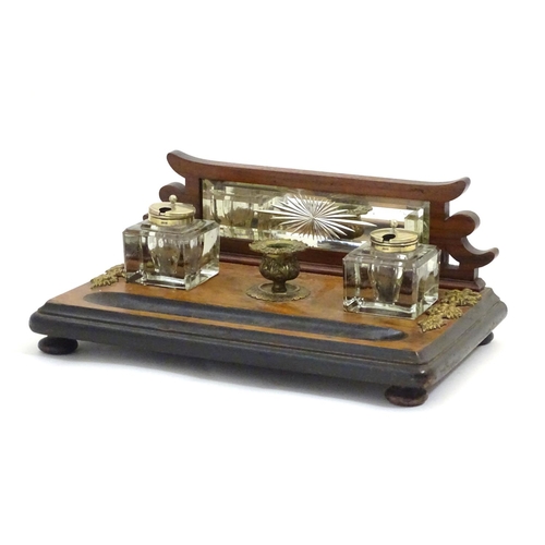 1004 - A Victorian desk standish with a central taper stick flanked by two glass inkwells, the base with ap... 