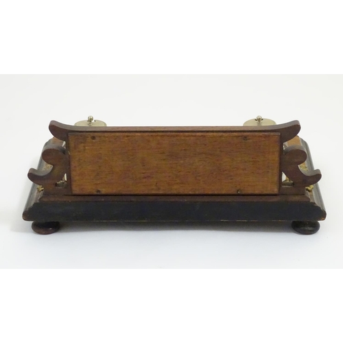 1004 - A Victorian desk standish with a central taper stick flanked by two glass inkwells, the base with ap... 