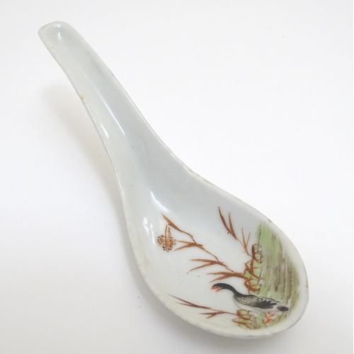 21 - A Chinese rice / soup spoon with hand painted decoration depicting a goose / bird in a wetland lands... 