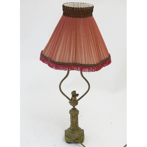 1516 - A mid to late 20thC brass table lamp, formed as a Corinthian column surmounted by a putto. 22