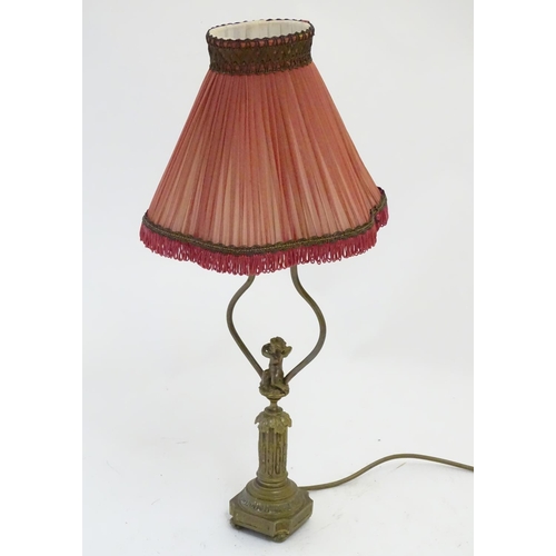 1516 - A mid to late 20thC brass table lamp, formed as a Corinthian column surmounted by a putto. 22