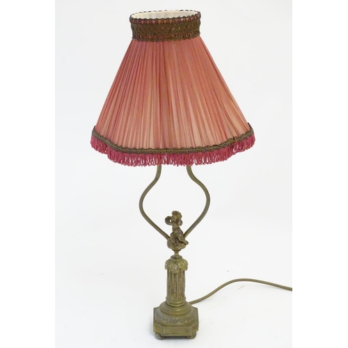 1516 - A mid to late 20thC brass table lamp, formed as a Corinthian column surmounted by a putto. 22