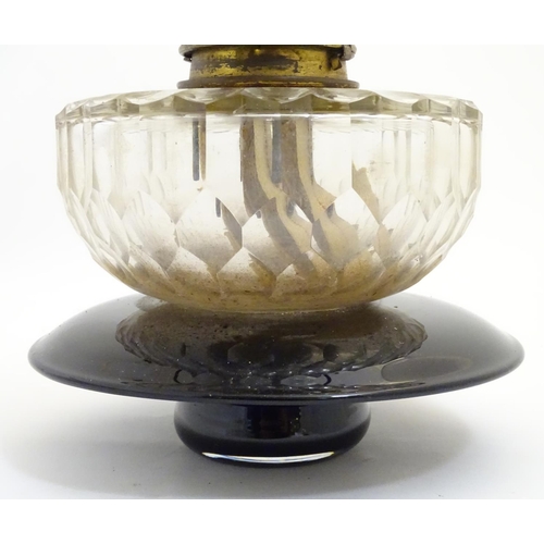 1524 - A 19thC oil lamp, the black glass base with facet cut glass reservoir and white milk glass shade. Th... 