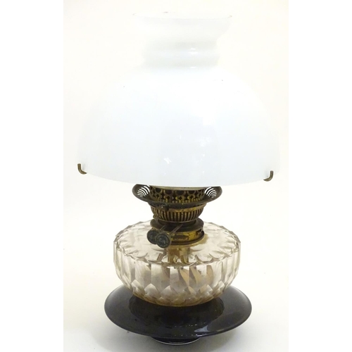 1524 - A 19thC oil lamp, the black glass base with facet cut glass reservoir and white milk glass shade. Th... 